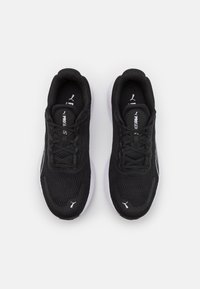 Zapatos deportivos negros con parte superior de malla, diseño con cordones y suela de goma blanca. Presenta un sutil logotipo en la lengüeta y en el costado.