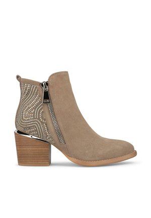 Stivale in suede beige alla caviglia con tacco grosso, dotato di una zip decorativa in argento e un design borchiato su un lato, con una texture liscia complessiva.