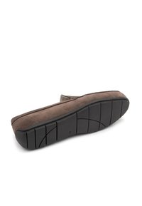 Pantofii slip-on din suede maro au o talpă flexibilă din cauciuc negru, având un profil joasă și detalii de cusătură discrete pe margini.