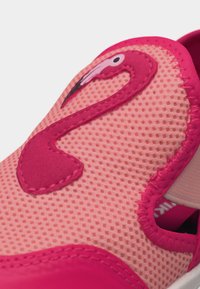 Detailný záber ružovej textúrovanej topánky so šitým dizajnom plameniaka na hornej časti pri otvorení.