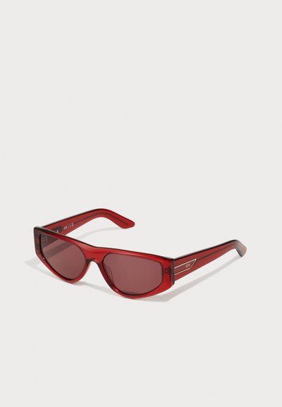 Rote Sonnenbrille mit rechteckigen Gläsern und schmal zulaufenden Bügeln. Hergestellt aus transparentem Kunststoff, mit einem leichten Farbverlauf und metallischen Details.