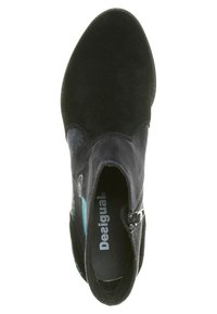 Bottine en daim noir avec un design festonné, une fermeture éclair latérale et des motifs colorés. Tige texturée avec une doublure intérieure lisse.