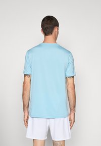 T-shirt bleu clair à manches courtes fabriqué à partir d'un matériau lisse et léger. Présente un col rond classique et une coupe décontractée. Pas de motifs visibles.