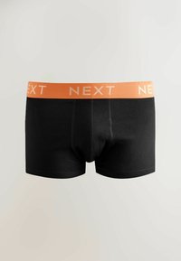 Chiloți boxer negri cu o talie portocalie, prezentând cuvântul „NEXT” repetat în litere bej deschis.