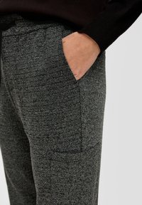 Grijze textuur broek met een subtiel visgraatpatroon. Heeft een zijzak en een elastische tailleband voor extra comfort. De stof is geweven en stevig.
