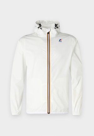 Giacca leggera bianca con colletto alto, zip a righe contrastanti in rosso, blu e giallo, con polsini elasticizzati e un logo sul petto.