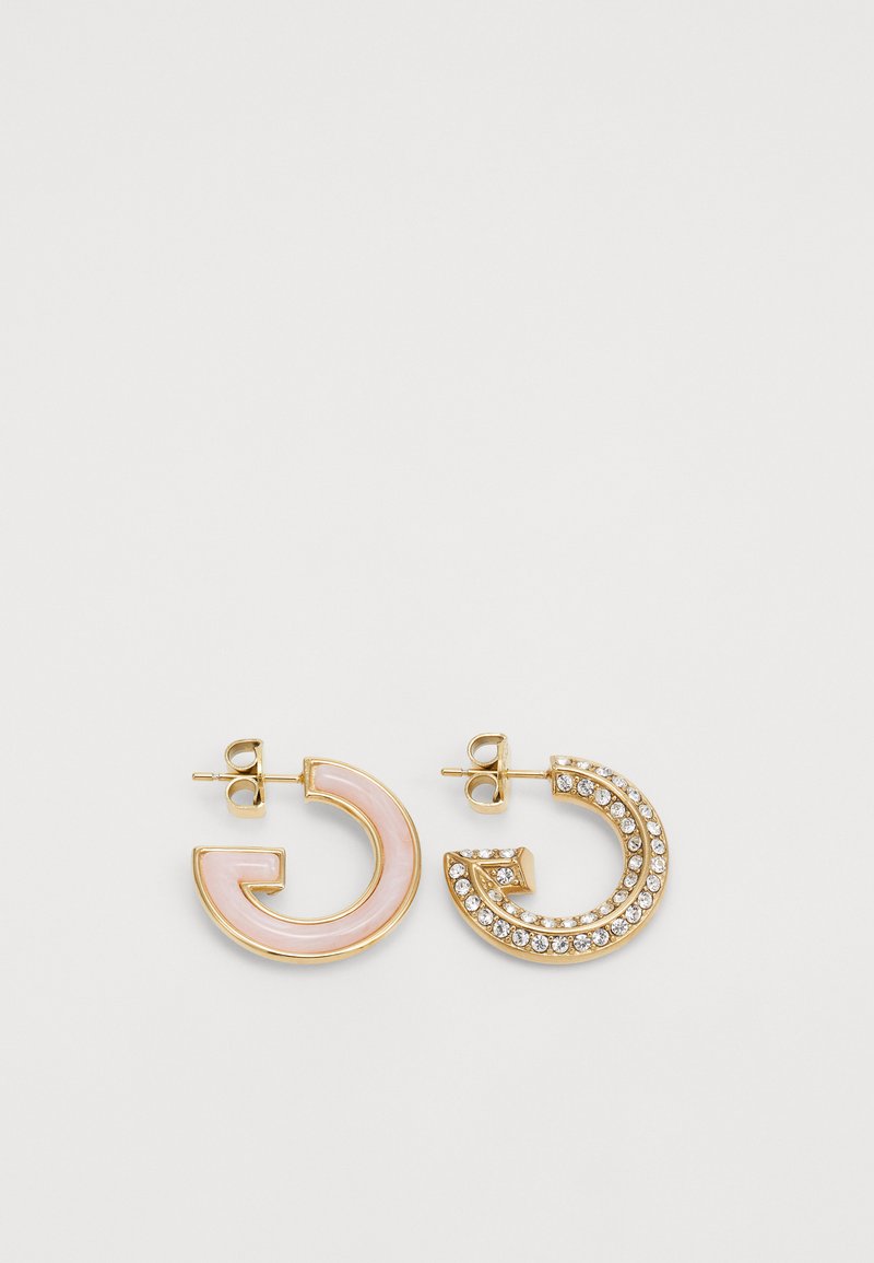 Gold hoop earrings featuring one with a pink enamel finish and the other adorned with clear rhinestones in a curved design.