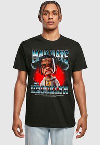 Svart bomull T-skjorte med et tegneserieillustrasjon av en karakter med tegneserieaktige ansiktstrekk, teksten "MAD DAYS IN BROOKLYN," og fargerike detaljer.