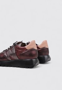 Sneakers in pelle con una combinazione di colori bordeaux e rosa. Finitura testurizzata, punta rotonda e una spessa suola nera. Presentano dettagli e lacci a contrasto.