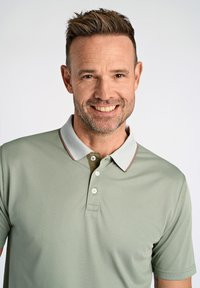 Ljusgrön polo med grå krage och bruna detaljer, med en treknapps placket och korta ärmar, tillverkad av strukturerad tyg.