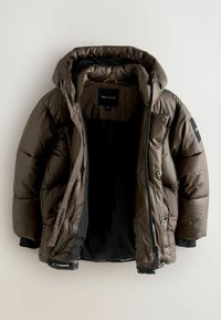 Brun puffjacka med huva, som har dragkedjestängning, tryckknappar och svarta detaljer. Insidan är klädd i svart tyg.