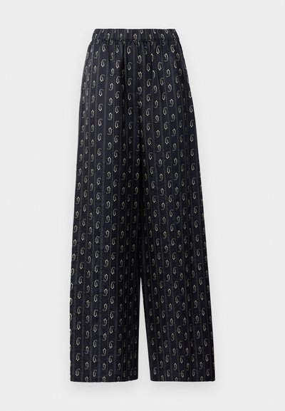 Schwarz-weiße weite Hosen mit elastischem Bund, aus dunklem Stoff mit einem goldenen ovalen Muster und vertikalen Streifen. Leicht und strukturiert.