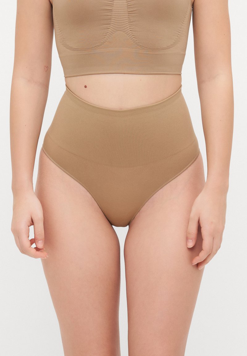 Mutandine a vita alta senza cuciture di colore nude, caratterizzate da una texture liscia e senza cuciture visibili per una vestibilitàresa.
