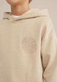 Beige Kapuzenpullover mit strukturiertem Design. Verfügt über eine Fronttasche, einen verstellbaren Kordelzug und ein dezentes Logo, das auf der linken Seite aufgedruckt ist. Weicher Stoff.