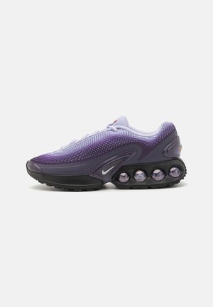 Vijolični in črni Nike teniski z mrežasto zgornjim delom, zaobljenim nosom in edinstvenim oblazinjenim podplatom, ki vsebuje vidne zračne žepke.