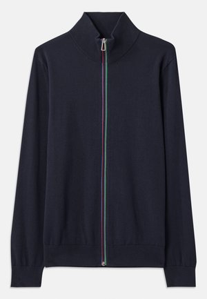 Marineblå zip-up cardigan med høj krave, der har en flerfarvet lynlås og ribbede manchetter. Lavet af et blødt strikkemateriale.