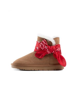 Brune ruskinds ankelstøvle med hvidt kunstpelsfor og et rødt bandana bundet omkring skaftet. Flad gummisål med struktureret mønster.