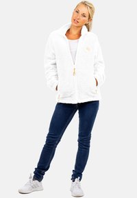 Witte fleece zip-up jas met een hoge kraag en gouden ritsaccenten, voorzien van twee voorzakken en een gestructureerde stof voor warmte.