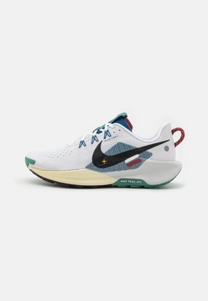 Chaussure de course blanche Nike avec swoosh noir, accents bleus, semelle beige, semelle extérieure verte et boucle rouge au talon, vue de côté.
