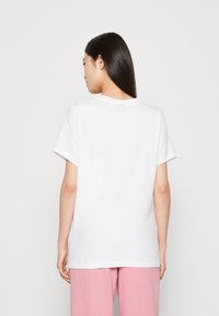 White short-sleeve t-shirt with a crew neckline, made from cotton. The back shows a relaxed fit, smooth texture, and no visible patterns.