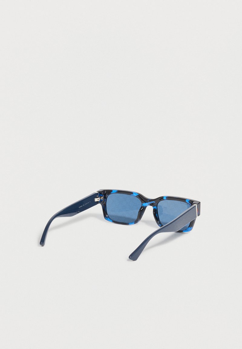 Occhiali da sole rettangolari con lente tinta di blu, montatura marmorizzata nera e blu e aste curve blu scuro su sfondo bianco.