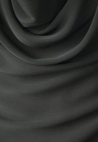 Tessuto grigio scuro con una texture liscia, caratterizzato da linee orizzontali sottili e pieghe drappeggiate che creano profondità e dimensione.