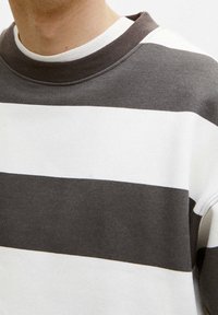 Sudadera a rayas con franjas horizontales alternas en gris oscuro y blanco, cuello acanalado y mezcla de algodón suave y texturizada.