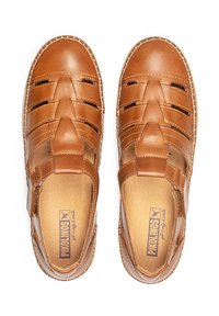 Sandalias de cuero marrón con un diseño trenzado, punta descubierta, correa ajustable y plantillas de color marrón claro. Presenta costuras visibles alrededor de los bordes.