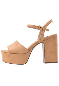Hnědé semišové platformové sandály s širokým křížovým páskem, nastavitelným nártem a silným vysokým podpatkem, které mají hladkou texturu a minimální akcenty.