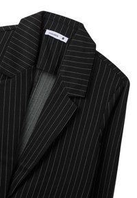 Blazer nero a righe con ampio colletto a punte, caratterizzato da una texture liscia e una zip frontale nascosta. Etichetta che riporta "Terranova," taglia S.