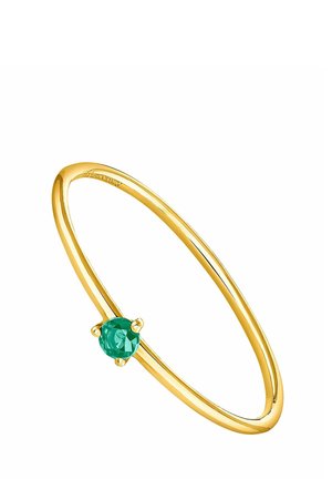 Anillo fino de oro con una sola piedra preciosa verde redonda pequeña montada en un engaste de cuatro garras sobre un fondo blanco.