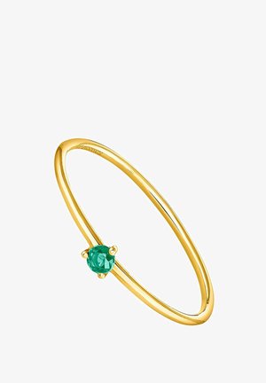 Anillo fino de oro con una sola piedra preciosa verde redonda pequeña montada en un engaste de cuatro garras sobre un fondo blanco.