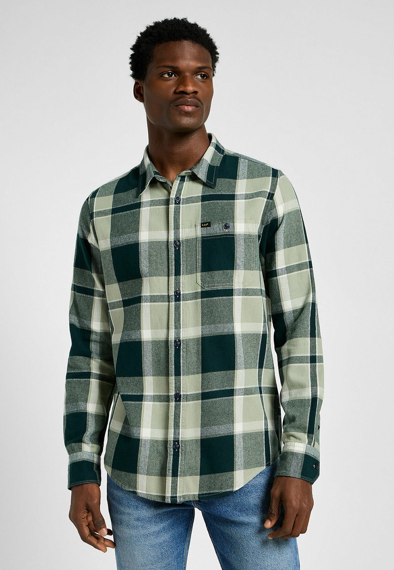 Groen en crèmekleurig geruit overhemd met een button-down kraag, een zak aan de voorkant en een merklabel. Gemaakt van zacht materiaal met een gestructureerde afwerking.