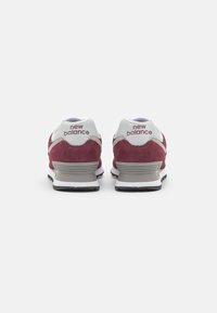 Bordo i bijeli tenisice s nubuk gornjištem, mekanim ovratnikom i teksturiranom potplatom, s "new balance" logom straga.