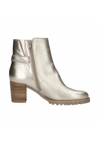 Metallic silberne Knöchelstiefelette mit seitlichem Reißverschluss, einem Holzblockabsatz und einer strukturierten Sohle. Merkmale sind ein geschwungenes Design und minimales Stitching.