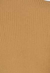 Ribattu ruskea kangas, jossa on pystysuorat viivat ja sileä pinta, korostaen istuvaa muotoilua ja lämpimiä, maanläheisiä värejä.