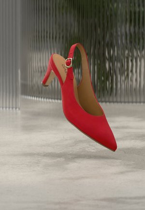 Rode suède slingback pump met een spitse neus en een lage hak. Voorzien van een gespdetail op het gesloten hielriempje. Gelijkmatige textuur overal.