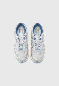 Szaro-srebrne buty sportowe z siateczkową cholewką, jasnoniebieskimi akcentami i sznurówkami, amortyzowaną podeszwą oraz logo na języku i boku.