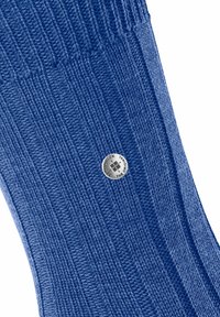 Chaussette bleue côtelée en tissu doux, présentant un accent de logo métallique. La texture est marquée par des lignes verticales.