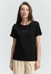 Zwarte katoenen t-shirt met korte opgerolde mouwen en ronde halslijn, voorzien van een klein grijs "TOM TAILOR" logo afgedrukt op de voorkant.