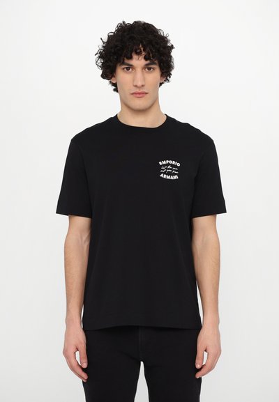Tricou din bumbac negru cu guler rotund, mâneci scurte, prezentând text alb tipărit pe partea stângă. Design simplu, cu tăietură dreaptă.