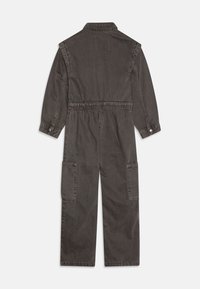 Tumehall jumpsuit pika varrukatega, elastse vöökoht ja kaks suurt küljetaskut. Valmistatud vastupidavast kangast, millel on sujuv tekstuur.