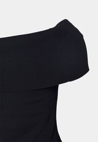 Černý pletený top bez ramínek s širokým skládacím výstřihem, zobrazený na jednoduchém světlém pozadí.