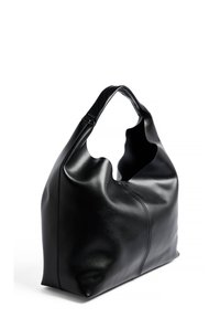 Schwarze Leder-Tote mit einem einzigartigen Ausschnitt-Griff, glatter Textur und minimalistischem Design, das auf einer Seite eine subtile Nahtdetails aufweist.
