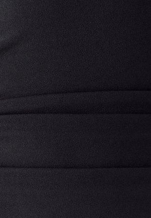 Gros plan sur un tissu en maille noir avec trois lignes de couture horizontales créant des sections matelassées subtiles.