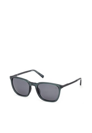 Dunkle rechteckige Sonnenbrille mit dünnen schwarzen Bügeln und leicht abgerundeten Kanten, dargestellt auf weißem Hintergrund.