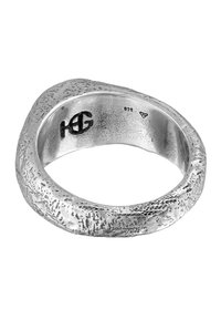 Ring i sterling silver med en texturerad, oregelbunden yta, med ingraverat varumärke och stämplade detaljer inuti.