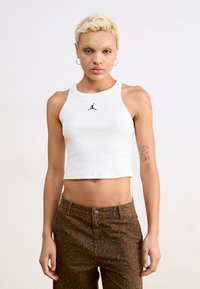 Fehér pamut, rövid ujjú tank top fekete Jordan log�óval; barna leopárdmintás, magas derekú nadrággal, amely gombos záródással rendelkezik.