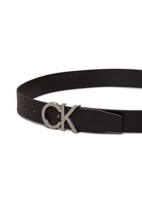 Svart lærbelte med jevn tekstur, utstyrt med en sølvfarget metallspenne med CK-logo og justerbare hull for størrelse.