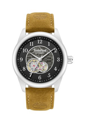 Timberland automātiskais pulkstenis ar melnu ciparnīcu, redzamām pārnesumkārbas detaļām, sudraba rokām, baltiem arābu cipariem un brūnas ādas siksniņu ar iespiestu koku logotipu.